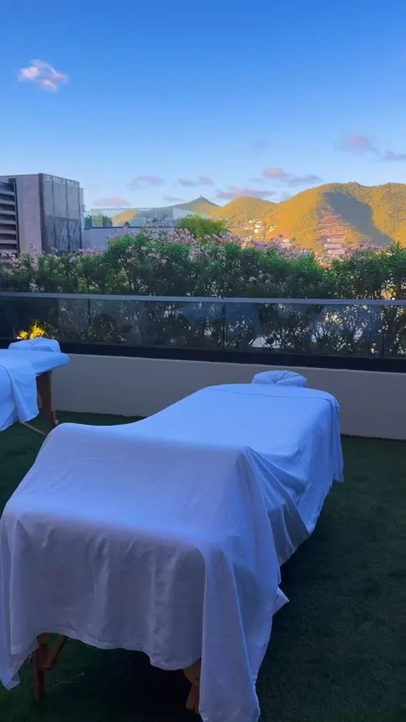 Massage tables set up and ready on a rooftop terrace at dusk with a mountain view in St. Maarten
